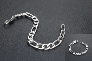 Close-up of silver Figaro chain bracelet with lobster clasp on black leather background