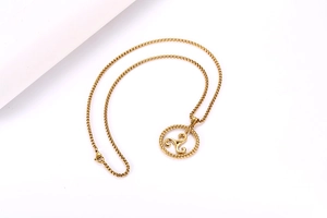 Detail shot of the golden triskelion pendant with a square link chain for rock style