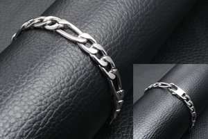 Detail of silver Figaro chain bracelet showing the flat clasp mechanism on black leather
