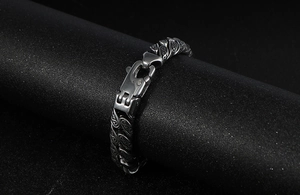 Macro detail of men's punk stainless steel bracelet with vintage baroque pattern engraving