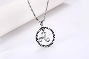 Macro shot of titanium steel Triskelion pendant with braided outer ring on square pearl chain