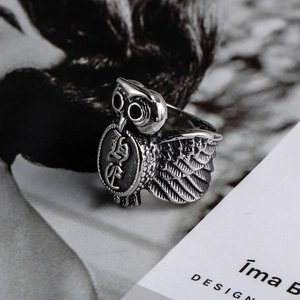 Close-up of retro stainless steel owl ring with detailed shield and punk feather texture