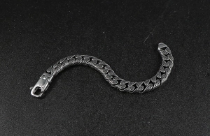 Detail of vintage carved patterns on heavy stainless steel bracelet with lobster clasp