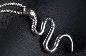 Macro detail van zilveren slangen hanger met schubtextuur op een Venetiaanse ketting
