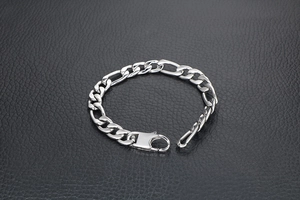 Polished silver Figaro chain bracelet with lobster clasp on black leather background