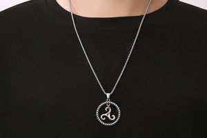 Close-up of titanium steel necklace with a Triskelion pendant on a box chain for men