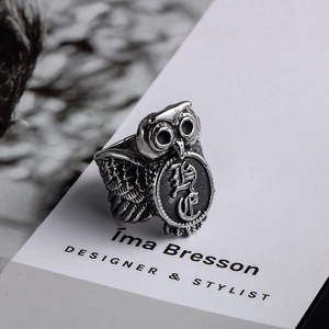 Macro shot of retro stainless steel owl ring featuring an embossed character engraving
