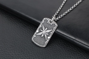 Detail of vintage silver military tag pendant with embossed star on black leather