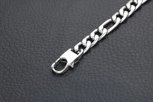 Close-up of silver Figaro link bracelet with polished finish and lobster clasp
