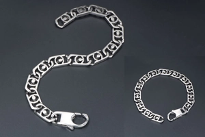 Détail des maillons évidés en acier inoxydable et grand fermoir mousqueton du bracelet