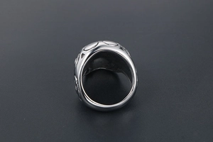 Macro d'une bague tête de mort en métal argenté avec relief géométrique et bord poli