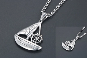 Macro detail of silver sailboat pendant and steering wheel with lucky inscription