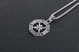 Macro shot of silver titanium steel octagonal star pendant with Greek key pattern