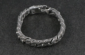 Detailed view of punk snake texture engraving on stainless steel chain link bracelet