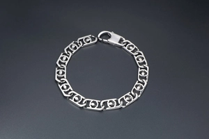 Détail des maillons géométriques creux et du fermoir mousqueton sur le bracelet en acier