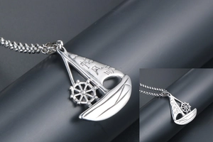 Macro shot of silver sailboat pendant featuring engraved traditional Chinese lettering