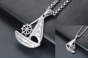 Detailed macro view of vintage stainless steel sailing boat pendant with engraving
