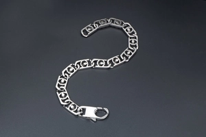 Vue macro des maillons géométriques creux sur un bracelet en acier inoxydable argenté