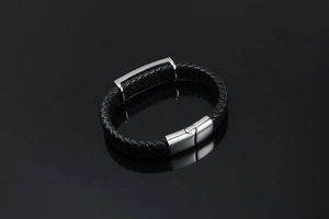 Gros plan d'un bracelet en cuir noir tressé avec fermoir en acier inoxydable poli