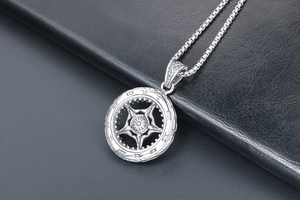 Vue macro du collier pendentif roue punk avec motif soleil vintage et chaîne à maillons carrés