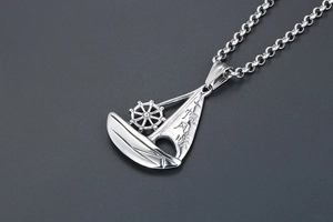 Detailed view of sailboat pendant with smooth sailing engraving and helm wheel detail