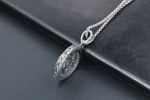 Macro d'un pendentif roue en argent vintage avec détails gravés sur cuir noir
