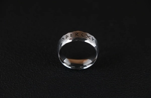 Macro side view of vintage titanium steel ring featuring engraved Nordic runes on wide band