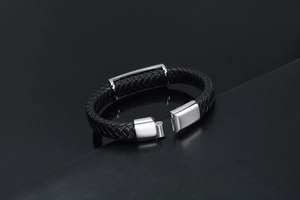 Gros plan d'un bracelet en cuir tressé noir avec un fermoir magnétique argenté brossé
