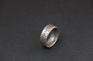 Macro shot of Viking runes ring with hammer-textured finish in vintage stainless steel