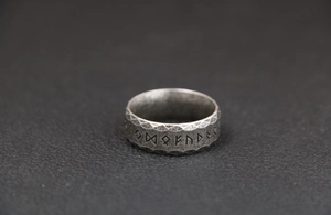 Detail shot of vintage titanium steel Norse runes ring with hammered metal texture