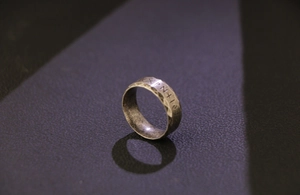Detailed macro shot of vintage Viking runes engraved on hammered titanium steel ring band