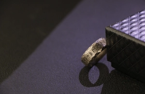 Macro shot of vintage Viking runes ring with hammered texture on black leather background