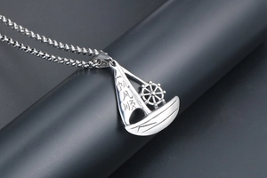 Detail shot of silver sailing boat pendant with smooth finish and Chinese engraving