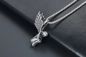 Détail du pendentif ange avec ailes ciselées et chaîne à maille miroir argentée