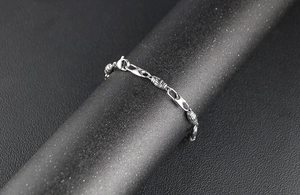 Detailed macro view of industrial style stainless steel chain link bracelet with textured beads