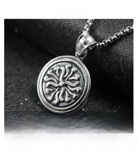 Macro view of retro stainless steel round medallion pendant with ornate sunburst engraving