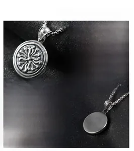 Detail of round stainless steel pendant with radial relief patterns and brushed metal back