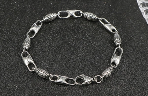 Detailed close-up of stainless steel bracelet with cylinder links and lobster clasp
