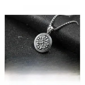 Detailed close-up of a vintage stainless steel sun totem pendant on a box chain necklace