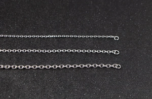 Detailed macro view showing three different widths of polished stainless steel link chains