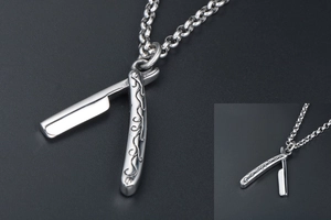Detailed macro view of vintage barber razor pendant with engraved vine motifs on steel chain