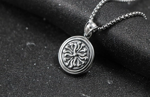 Macro shot of silver round sun wheel pendant on a black box chain for men and women