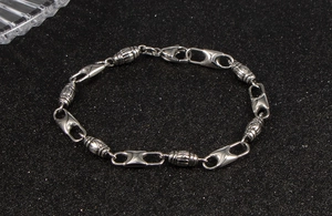Detail view of silver stainless steel bracelet featuring horse-eye links and textured beads