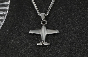 Detail of silver stainless steel airplane pendant with polished finish and wheat chain