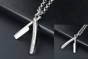 Macro shot of silver razor pendant with intricate floral engravings and round link chain