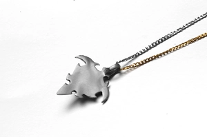 Detailed macro shot of a brushed titanium evil eye pendant with dual-tone metal chains