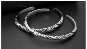 Detailed macro view of vintage totem cuff bracelets with intricate floral carvings