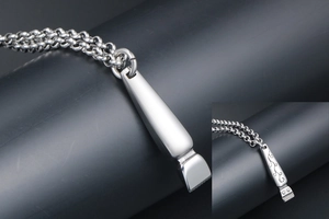 Macro detail of silver hair clipper pendant with vintage floral engraving on steel