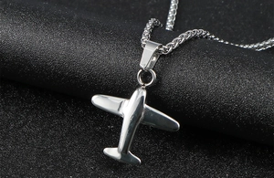 Macro view of polished silver stainless steel fighter plane pendant with wheat chain