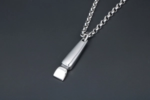 Macro shot of silver titanium hair clipper pendant with polished finish and chain